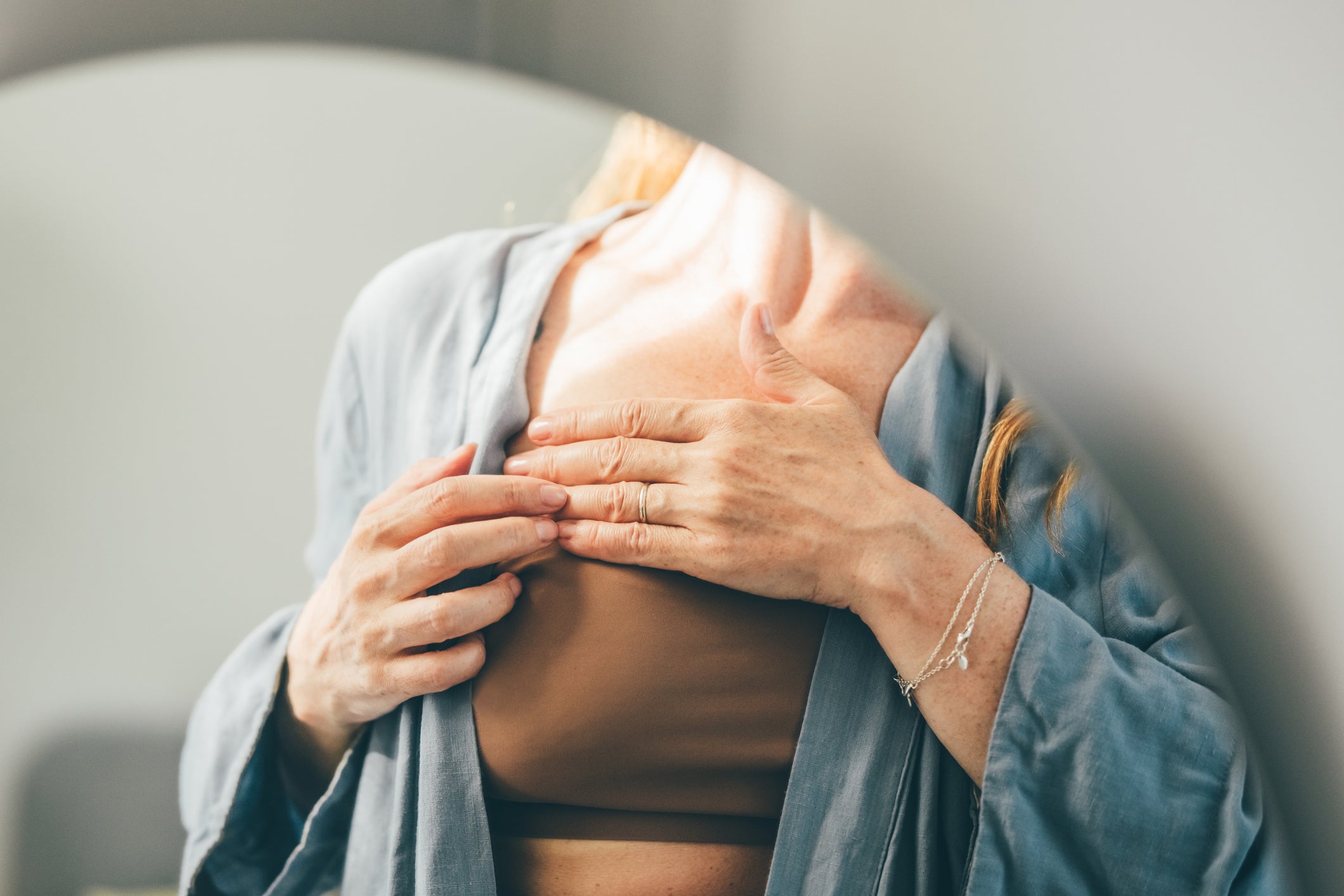 A woman self-examining her chest. She should see a specialist!
